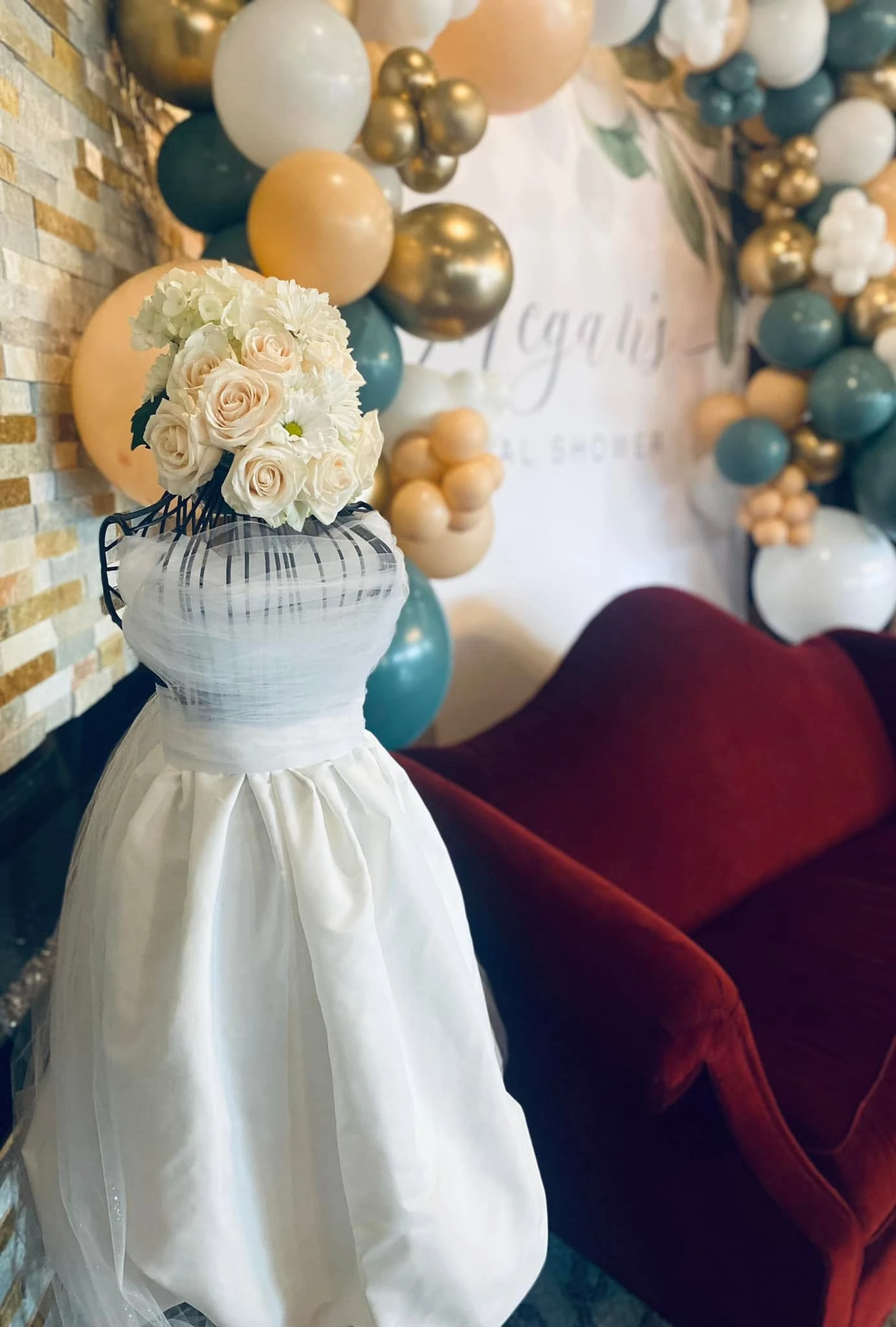 A party display with balloons, flowers, and a decorated mannequin